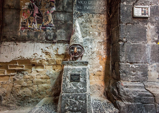 La statua di Pulcinella, opera di Lello Esposito nel cuore di Napoli, incanta i visitatori con il suo fascino e la promessa di fortuna. Simbolo di tradizione e abilità artistica, invita i turisti a toccare il suo naso per attrarre prosperità, raccontando così la storia e lo spirito vivace della città.